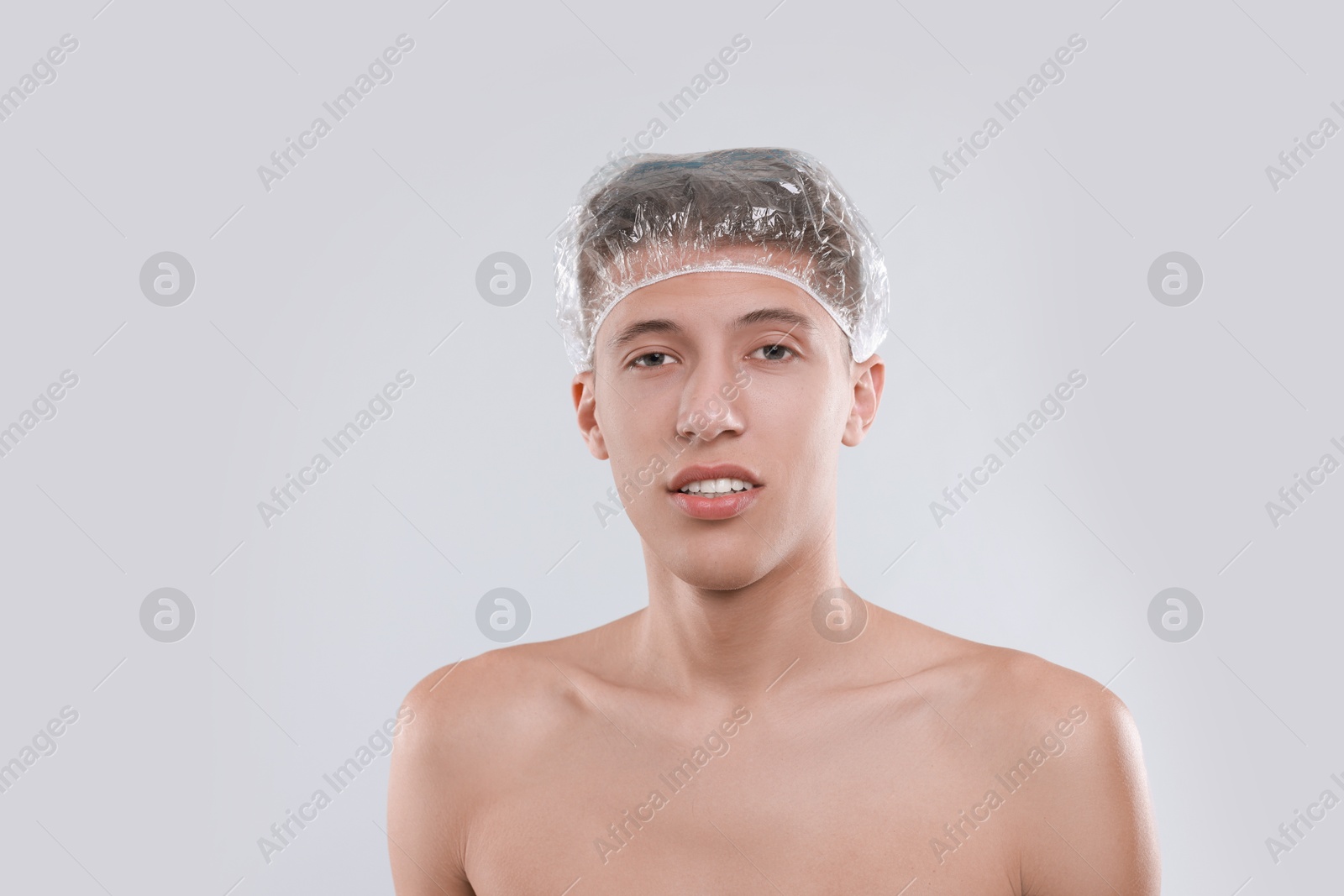 Photo of Man in shower cap on light grey background