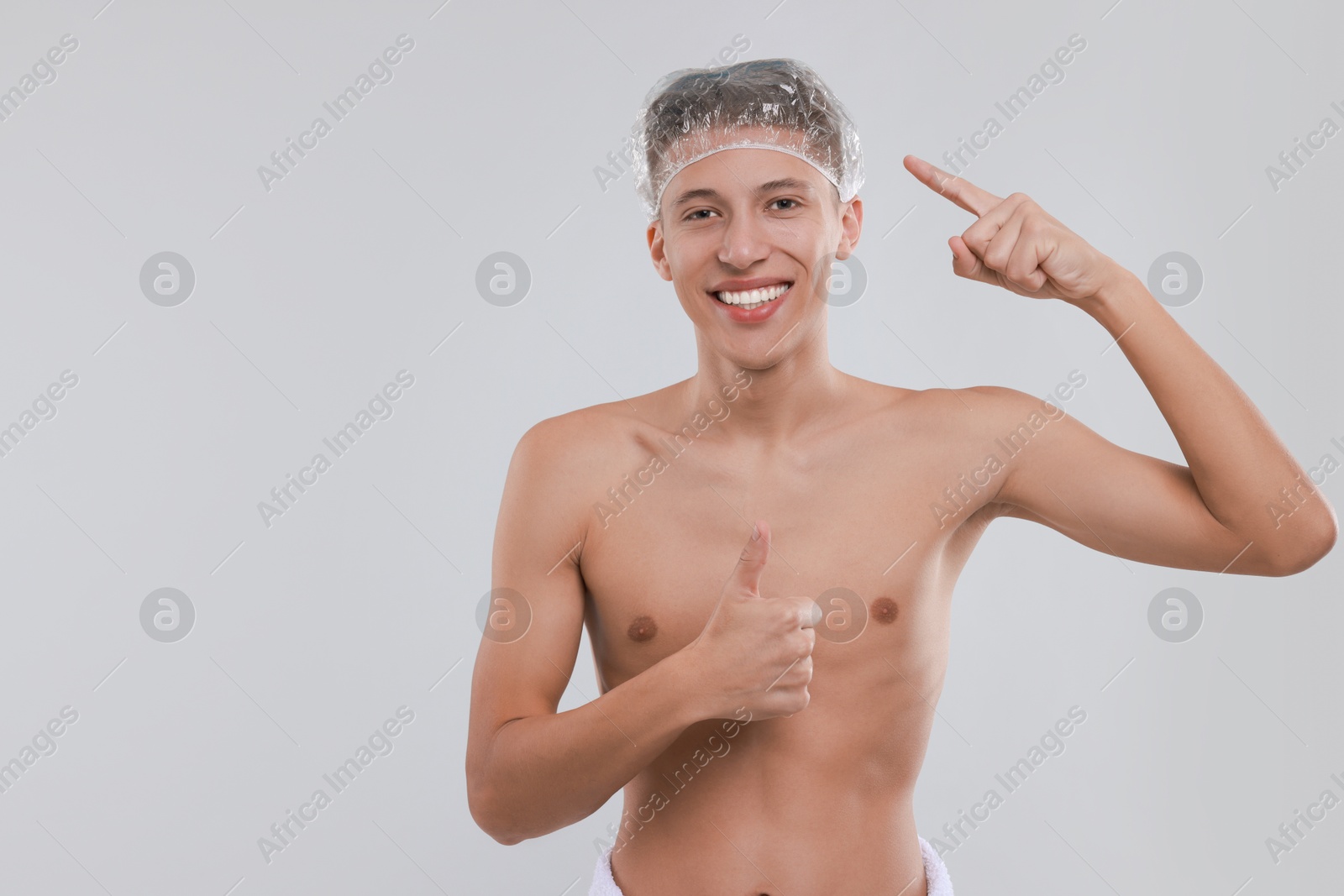 Photo of Man in shower cap on light grey background, space for text