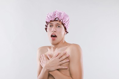 Man in shower cap on light grey background