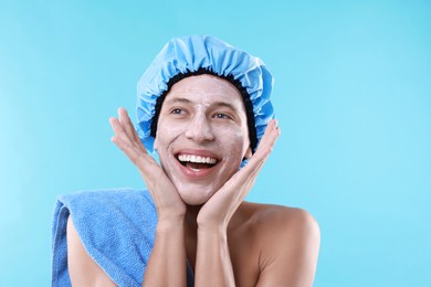 Photo of Man in shower cap with cream on his face against light blue background