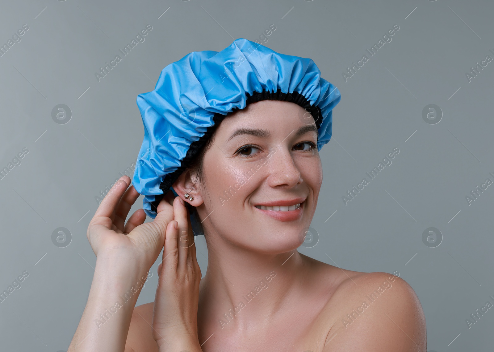 Photo of Woman wearing shower cap on grey background