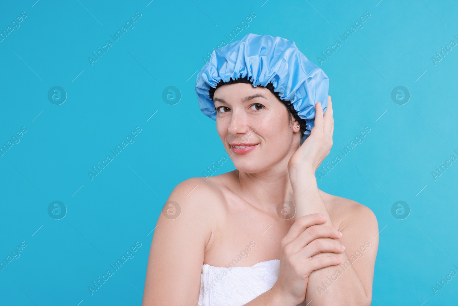 Photo of Woman wearing shower cap on light blue background