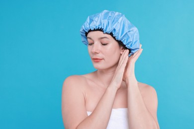 Photo of Woman wearing shower cap on light blue background