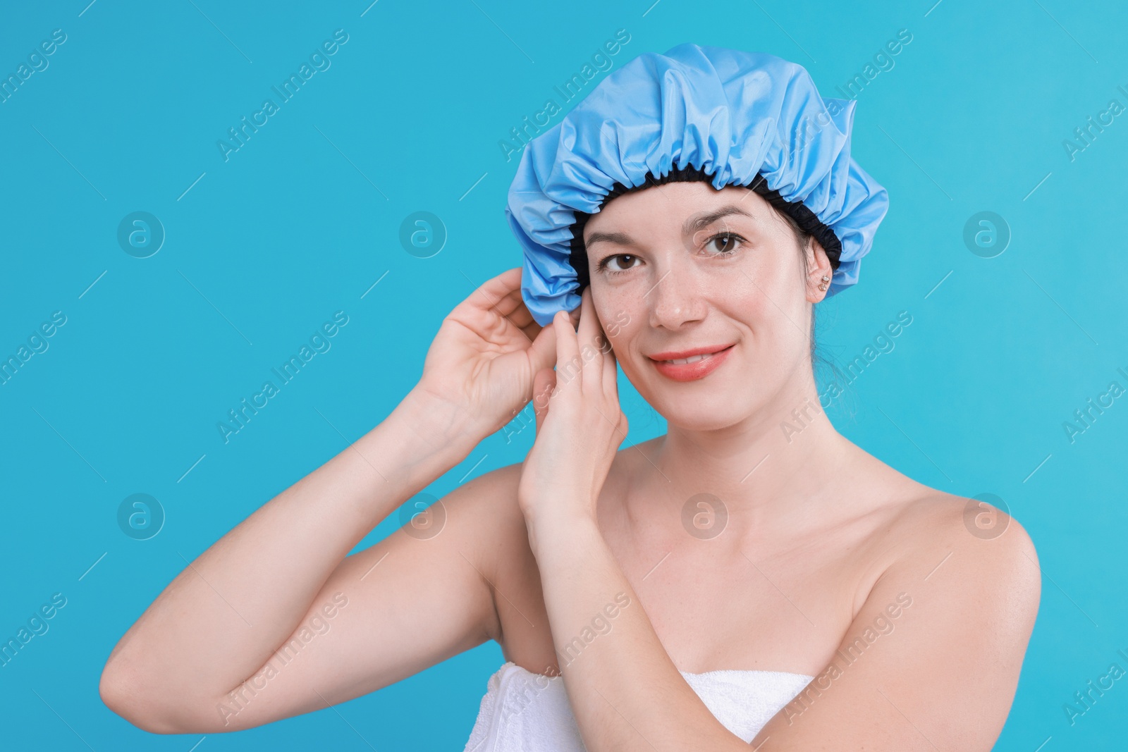 Photo of Woman wearing shower cap on light blue background