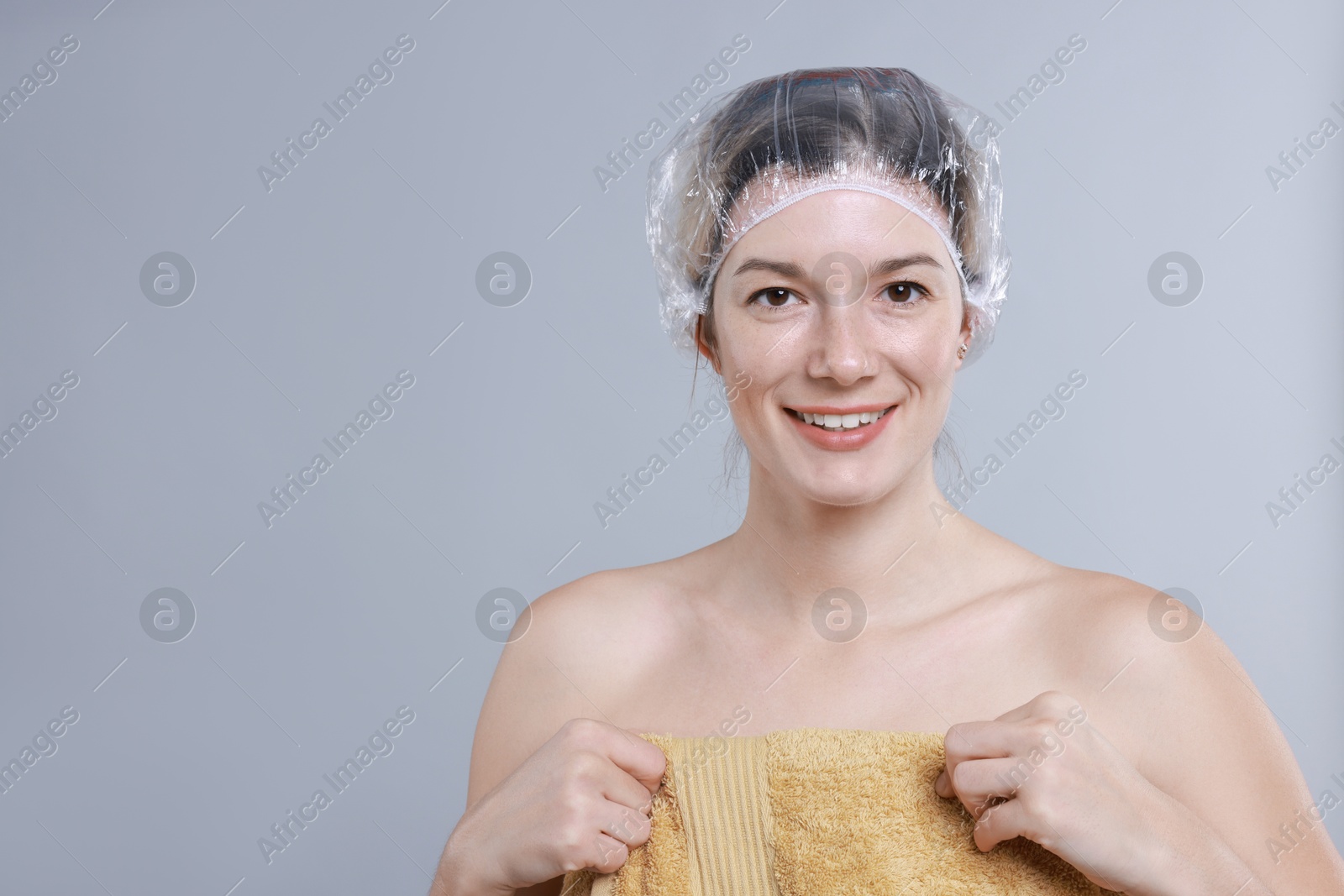 Photo of Woman in shower cap on grey background, space for text