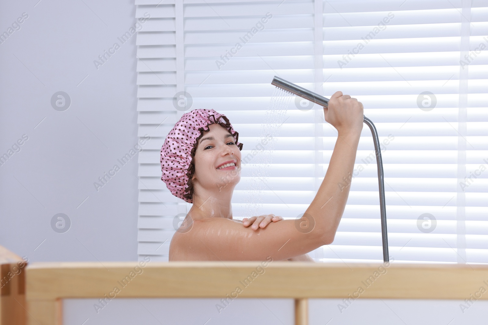 Photo of Woman with cap taking shower in bathroom