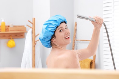 Photo of Woman with cap taking shower in bathroom