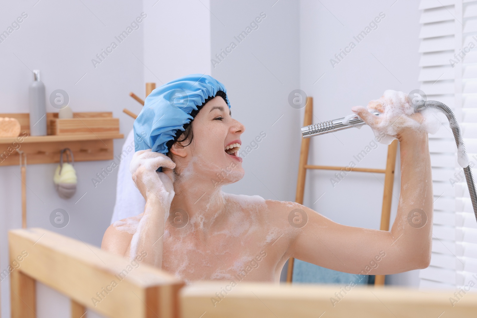 Photo of Woman with cap singing while taking shower in bathroom