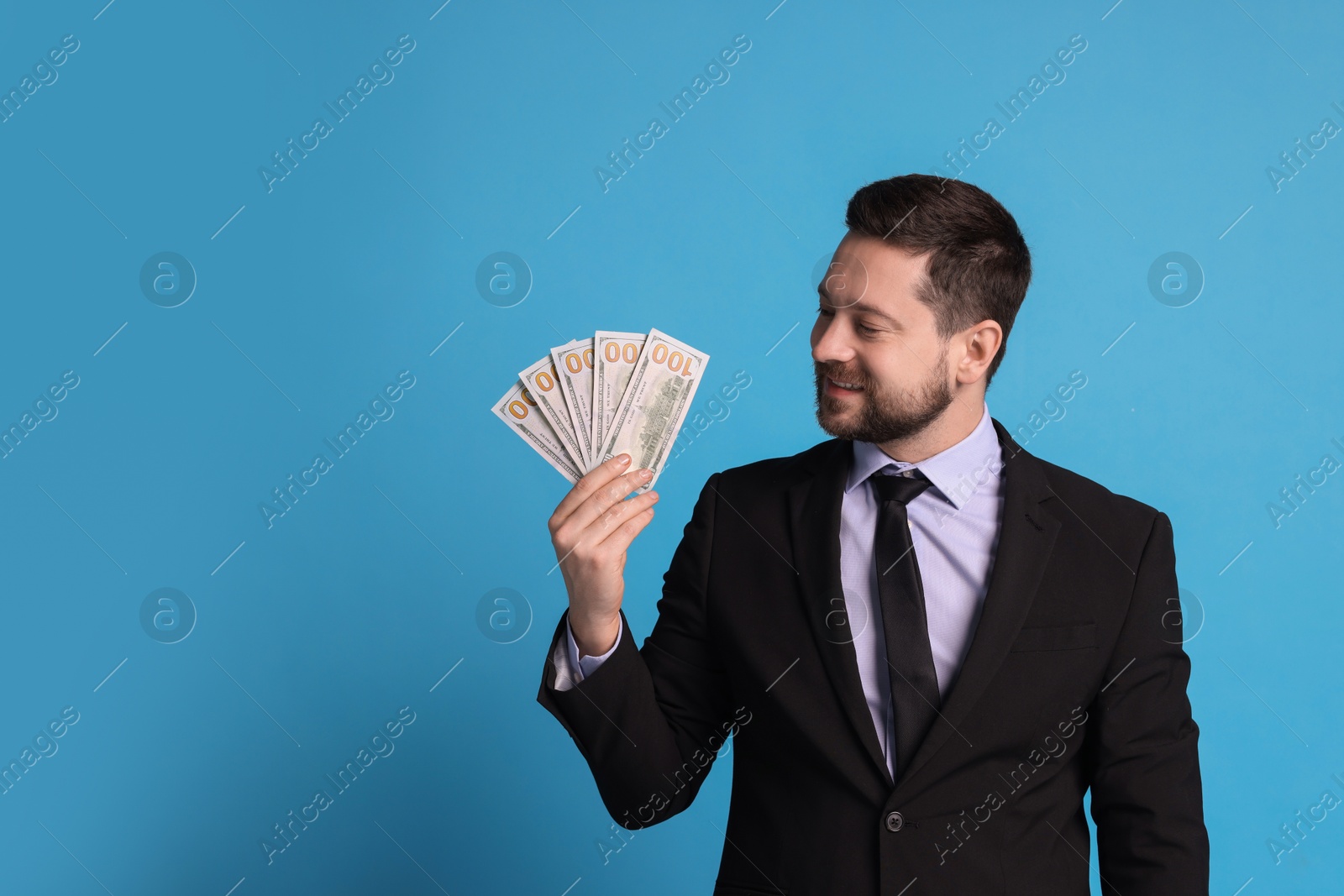 Photo of Banker with dollar banknotes on light blue background, space for text