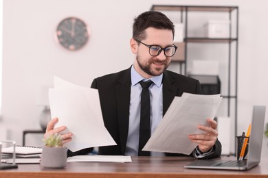 Banker working with documents at wooden table in office