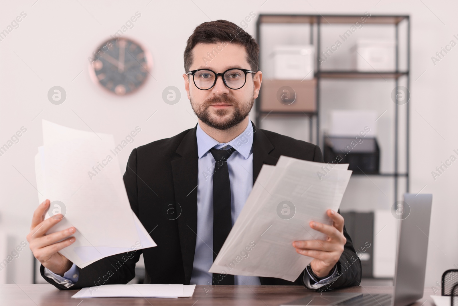 Photo of Banker working with documents at wooden table in office