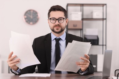 Banker working with documents at wooden table in office