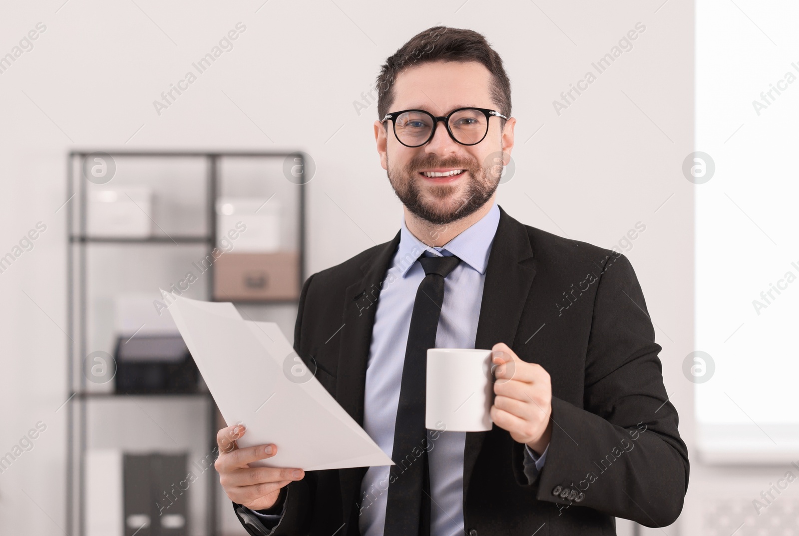 Photo of Banker with cup of drink and documents in office