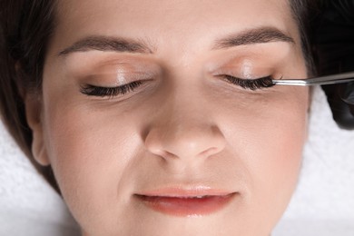 Photo of Woman undergoing lash extensions procedure in beauty salon, top view