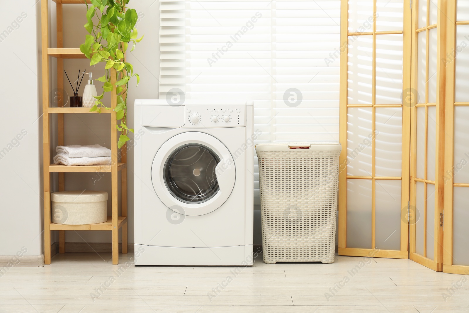 Photo of Wicker laundry basket and washing machine in bathroom