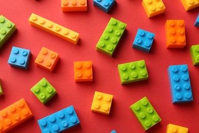 Photo of Construction toy. Colorful building bricks on red background, above view