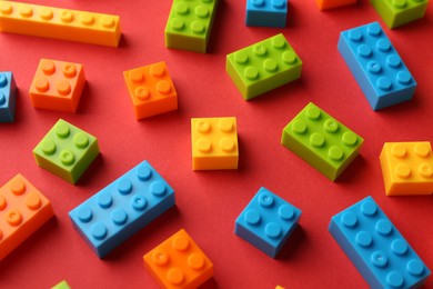 Photo of Construction toy. Colorful building bricks on red background, closeup