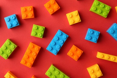 Photo of Construction toy. Colorful building bricks on red background, flat lay