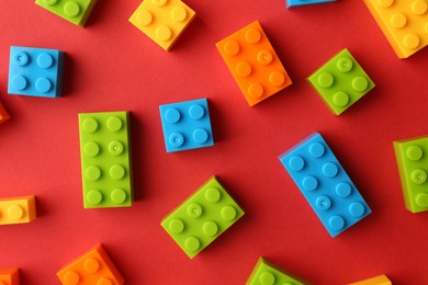 Photo of Construction toy. Colorful building bricks on red background, flat lay