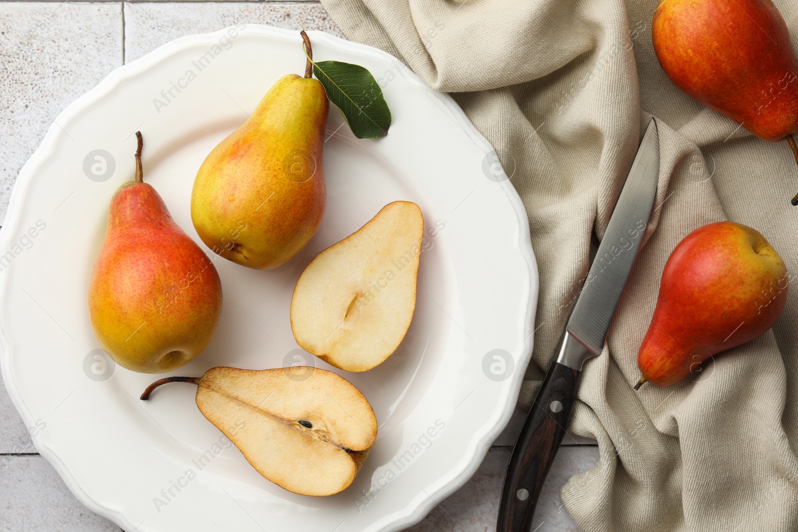 Photo of Ripe juicy pears on light tiled table, flat lay