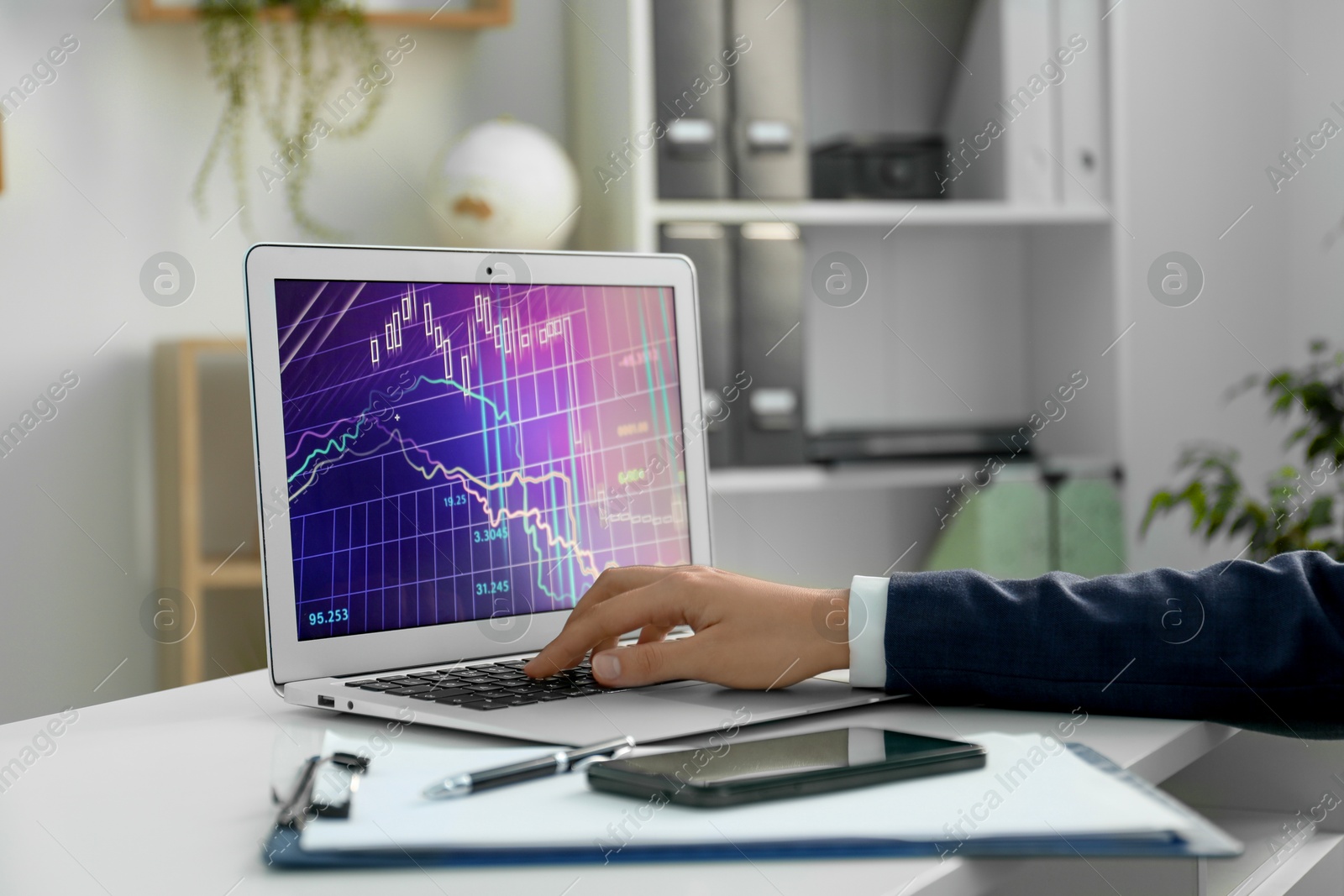 Photo of Businesswoman using laptop at white table indoors, closeup. Modern technology