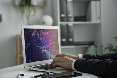 Photo of Businesswoman using laptop at white table indoors, closeup. Modern technology