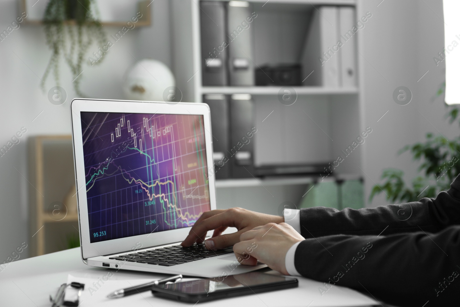 Photo of Businesswoman using laptop at white table indoors, closeup. Modern technology