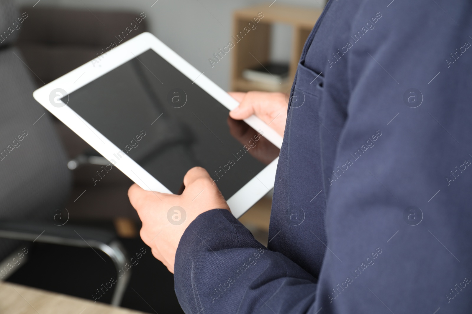 Photo of Businessman using tablet in office, closeup. Modern technology