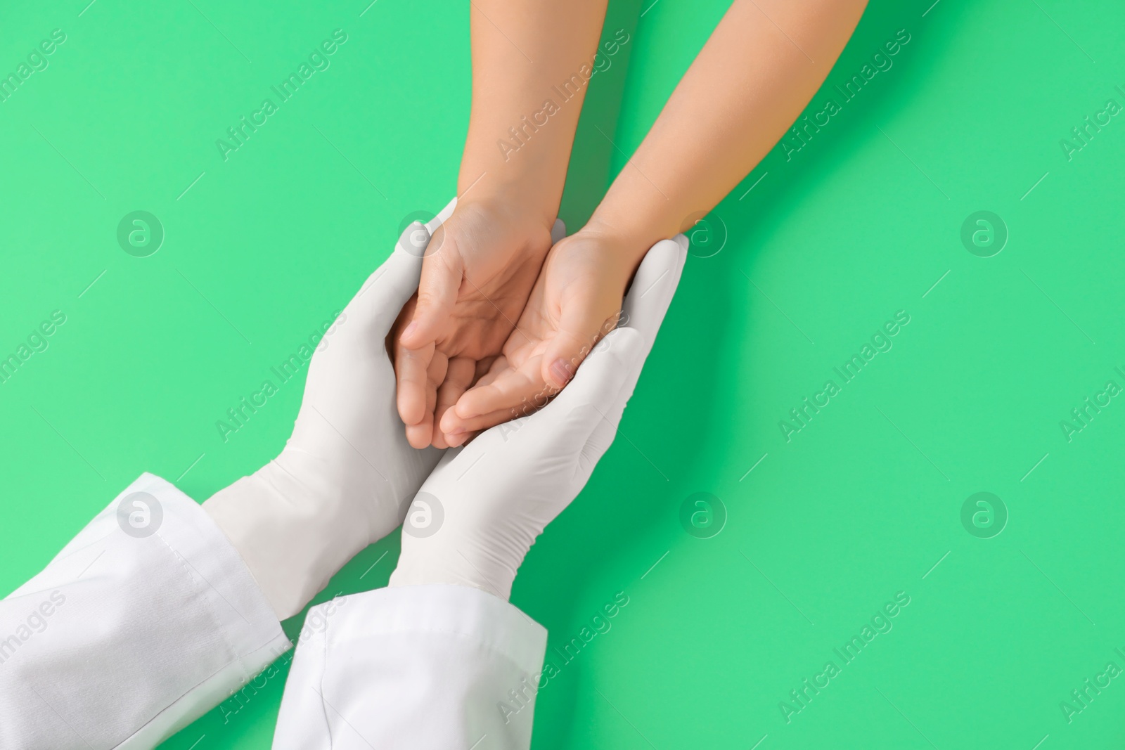 Photo of Doctor and child on light green background, top view