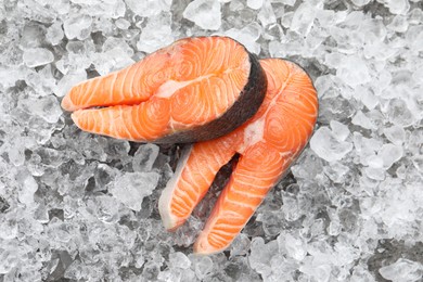 Photo of Fresh raw salmon steaks on ice pieces, top view