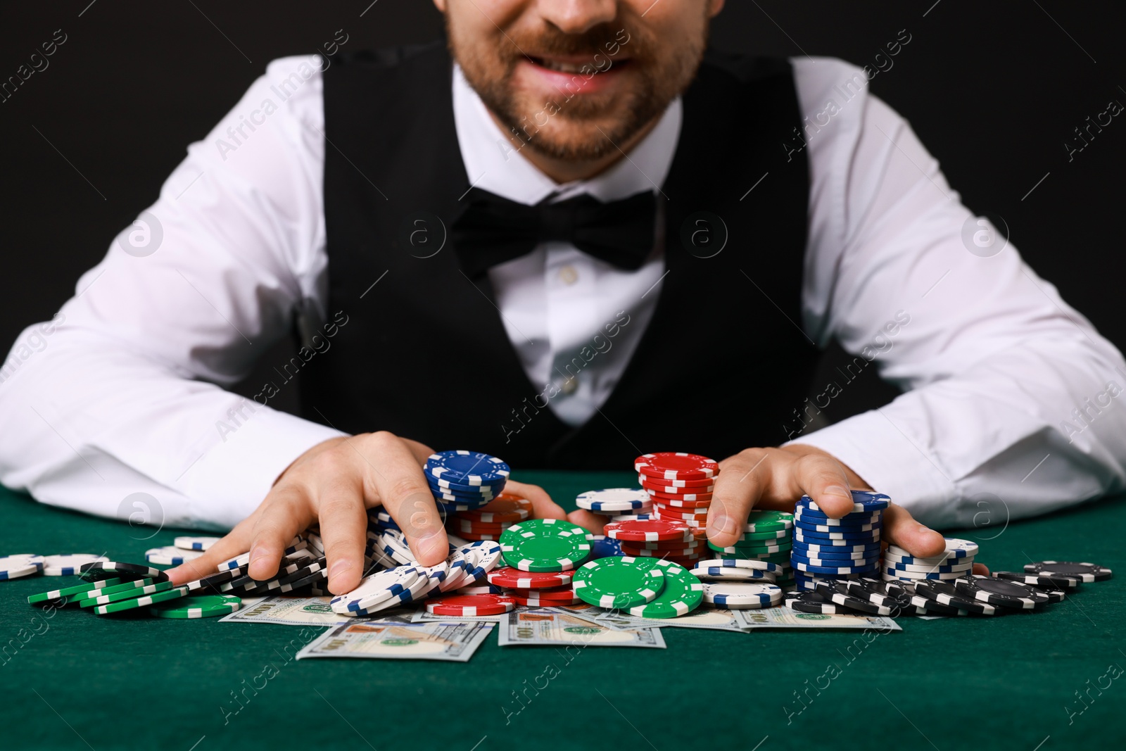 Photo of Professional croupier accepting bets at gambling table, closeup