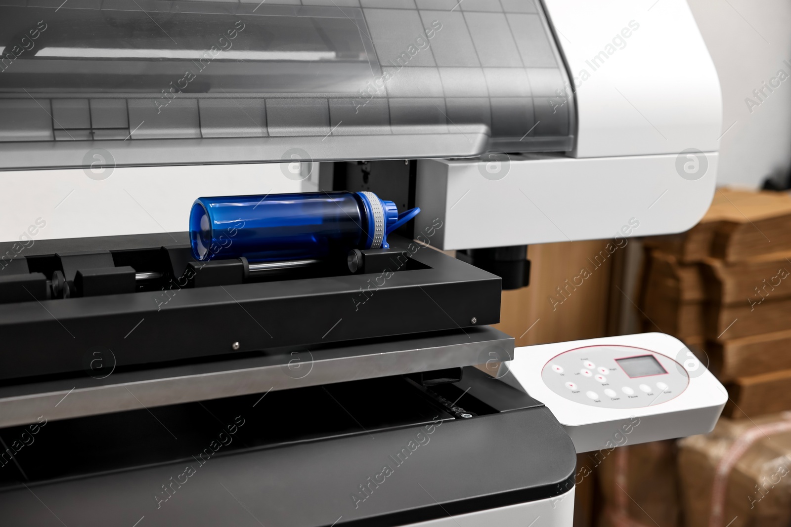 Photo of Modern printer and empty bottle indoors, closeup