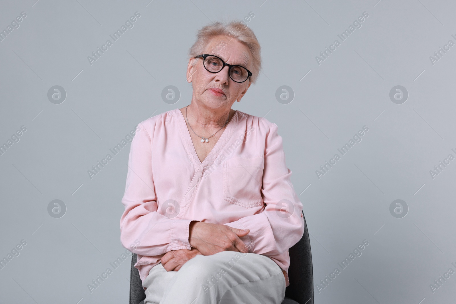 Photo of Senior woman on chair against light background