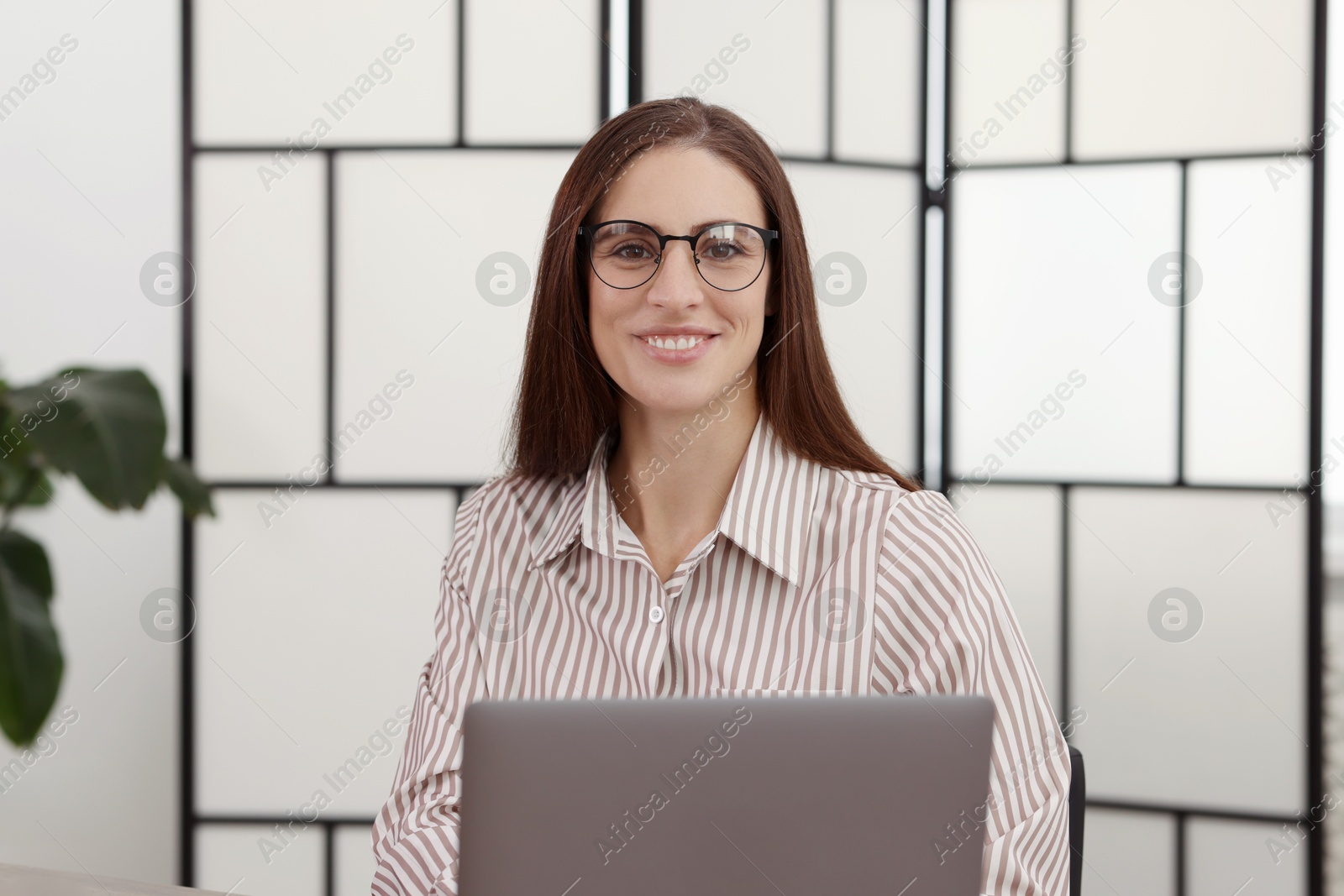 Photo of Portrait of banker working with laptop in office