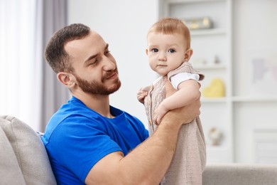 Father with his little baby on sofa at home