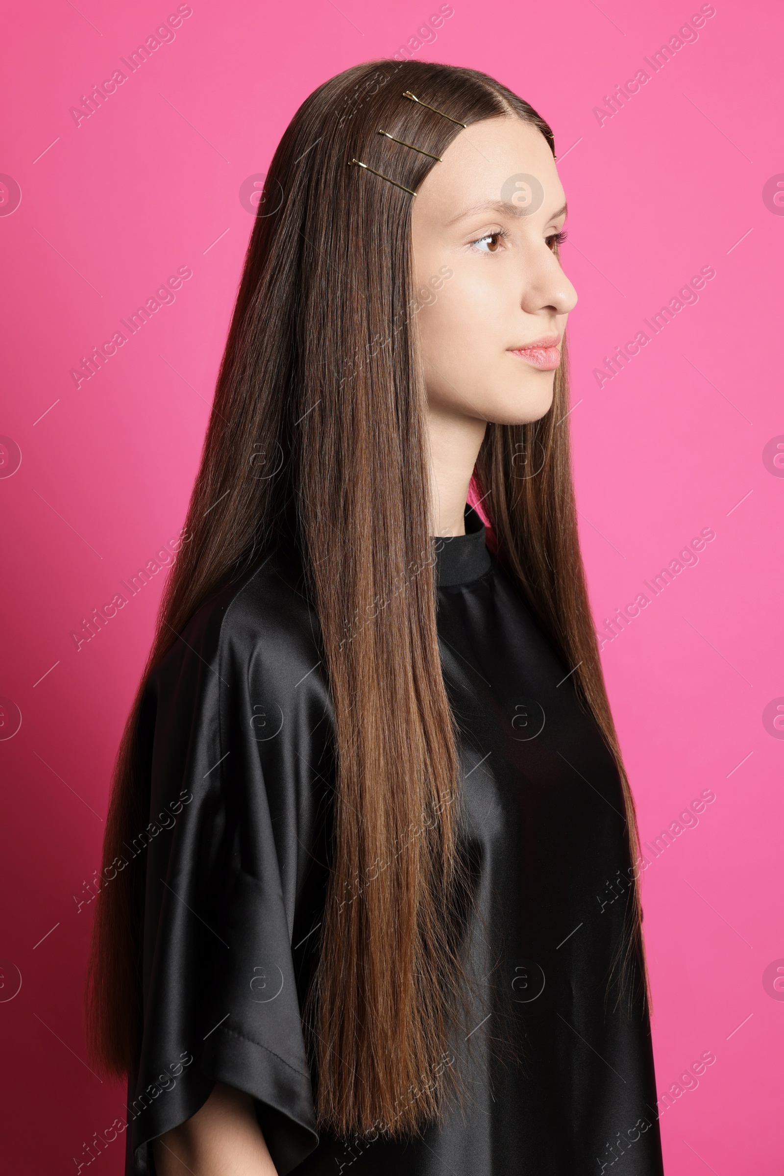 Photo of Teenage girl with stylish hair clips on pink background