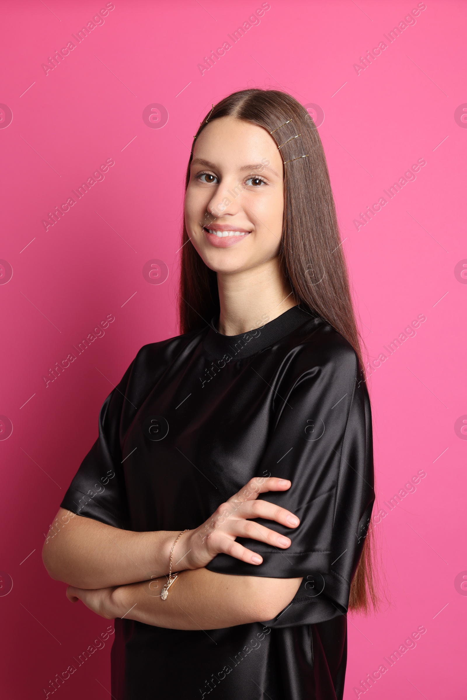 Photo of Teenage girl with stylish hair clips on pink background