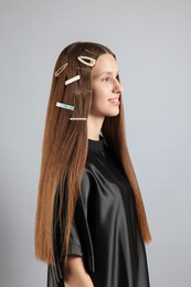 Photo of Teenage girl with stylish hair clips on light grey background