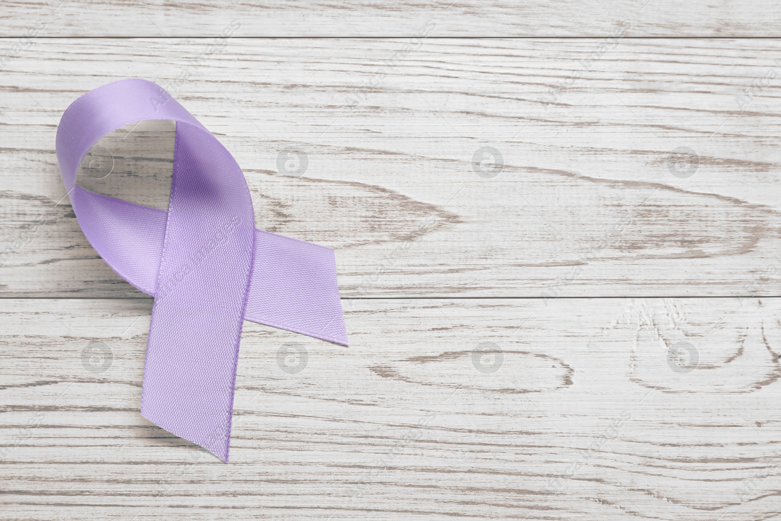 Photo of Violet awareness ribbon on wooden background, top view. Space for text