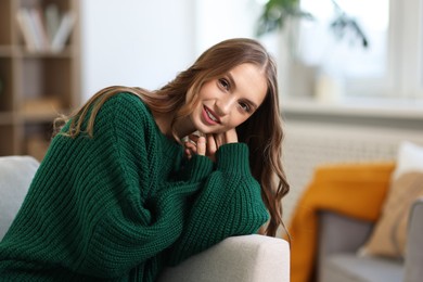 Photo of Charming young woman on sofa at home. Autumn atmosphere