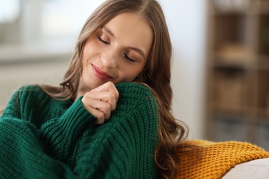 Photo of Charming young woman on sofa at home. Autumn atmosphere