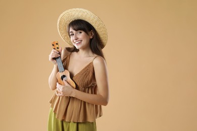 Happy woman playing ukulele on beige background, space for text