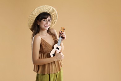 Happy woman playing ukulele on beige background, space for text