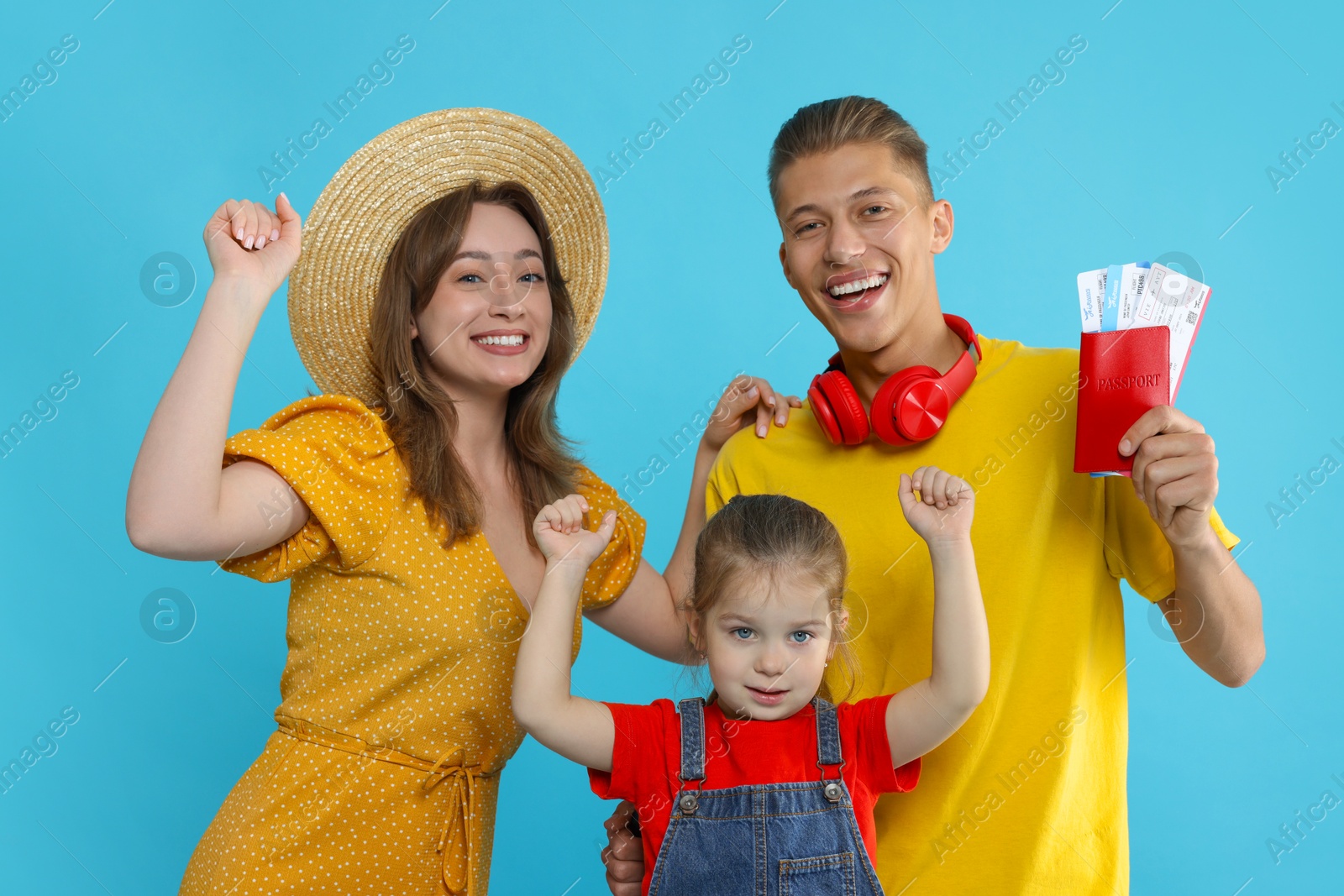 Photo of Travellers with passport and tickets. Happy family on light blue background