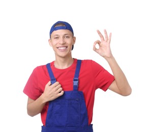 Happy young man in uniform showing OK gesture on white background