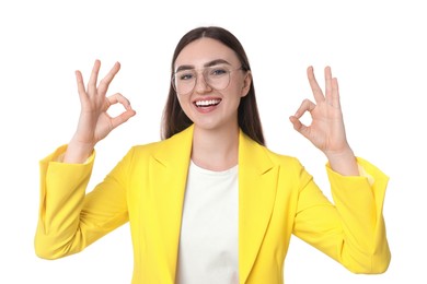 Happy young woman showing OK gesture on white background