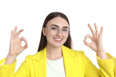 Photo of Happy young woman showing OK gesture on white background