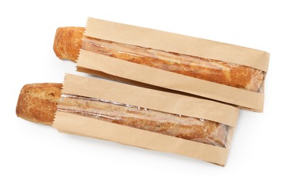 Photo of Fresh baguettes in paper bags isolated on white, top view