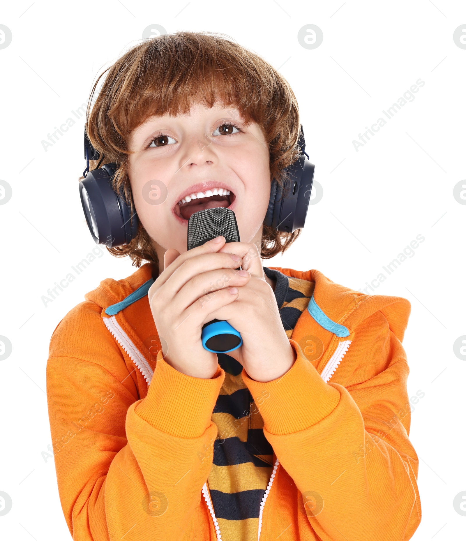 Photo of Little boy with microphone and headphones singing on white background