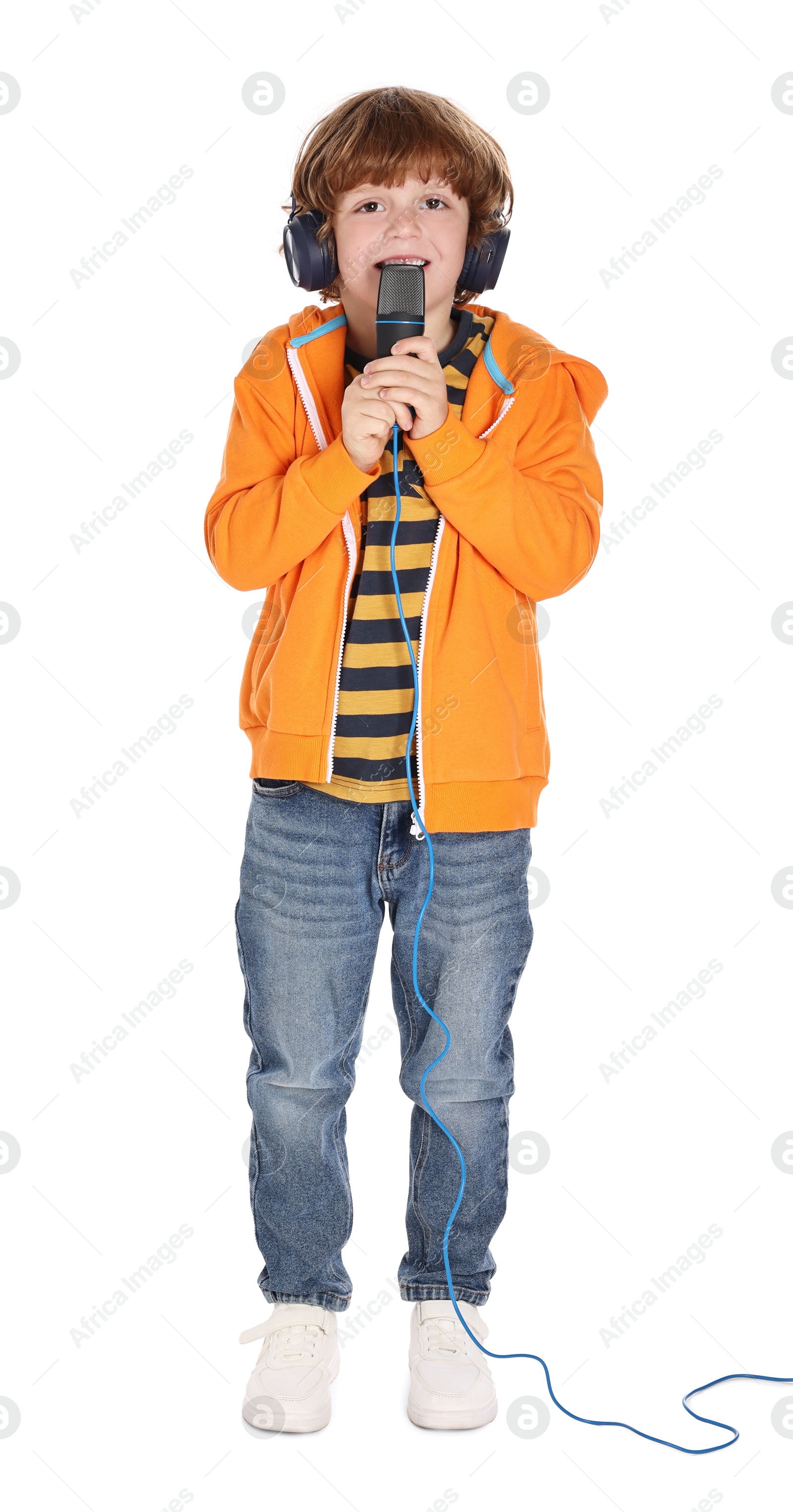 Photo of Little boy with microphone and headphones singing on white background